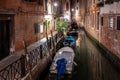 Narrow canal with boats and vintage houses at dusk. Venice city at night Royalty Free Stock Photo
