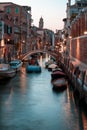 Narrow canal with boats and vintage houses at dusk. Venice city at night Royalty Free Stock Photo