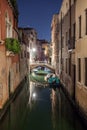 Narrow canal with boats and vintage houses at dusk. Venice city at night Royalty Free Stock Photo