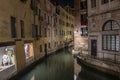 Narrow canal between historic residential building at night