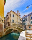 Narrow canal among old colorful brick houses in Venice, Italy. Royalty Free Stock Photo