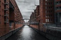 a narrow canal running through a city near tall buildings and a bridge, Hamburg, Germany