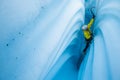 Narrow canyon of ice with wavy walls and an ice climber ascending the narrow slot Royalty Free Stock Photo