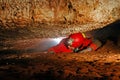 Narrow cave passage with a cave explorer