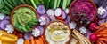 Narrow close up view of three dips surrounded by fresh cut vegetables for dipping. Royalty Free Stock Photo