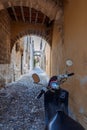 Narrow cobbled historical streets of Rhodes. Vintage scooter bike is parked old stone against wall of house, Rhodes