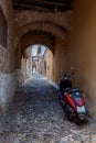 Narrow cobbled historical streets of Rhodes. Vintage scooter bike is parked old stone against wall of house, Rhodes