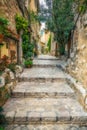 Narrow cobbled street with flowers in the old village Tourrettes-sur-Loup , France. Royalty Free Stock Photo