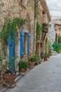 Narrow cobbled street with flowers in the old village Tourrettes-sur-Loup , France. Royalty Free Stock Photo