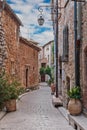 Narrow cobbled street with flowers in the old village Tourrettes-sur-Loup , France. Royalty Free Stock Photo