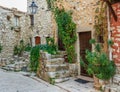 Narrow cobbled street with flowers in the old village Tourrettes-sur-Loup , France. Royalty Free Stock Photo