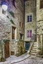 Narrow cobbled street with flowers in the old village Tourrettes-sur-Loup at night, France. Royalty Free Stock Photo