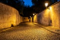 Narrow cobbled street illuminated by street lamps of Old Town, Prague, Czech Republic Royalty Free Stock Photo