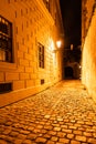 Narrow cobbled street illuminated by street lamps of Old Town, Prague, Czech Republic Royalty Free Stock Photo