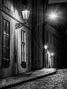 Narrow cobbled street illuminated by street lamps of Old Town, Prague, Czech Republic Royalty Free Stock Photo