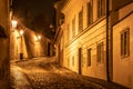 Narrow cobbled street in old medieval town with illuminated houses by vintage street lamps, Novy svet, Prague, Czech Royalty Free Stock Photo