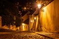 Narrow cobbled street in old medieval town with illuminated houses by vintage street lamps, Novy svet, Prague, Czech Royalty Free Stock Photo