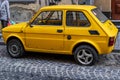 A narrow cobbled street with a small yellow car in the historic center of Lviv. Royalty Free Stock Photo