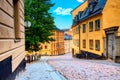 The narrow cobblestone street Bastugatan in Sodermalm with medieval houses in Stockholm at summer sunny day