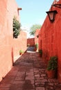 Narrow cobblestone street among vibrant orange color old buildings in Monastery of Santa Catalina, Arequipa, Peru Royalty Free Stock Photo