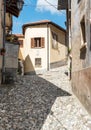 Narrow cobblestones streets with paintings on walls in ancient painted village Arcumeggia in province of Varese, Italy