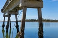 Narrow concrete fishing pier stretching into still blue waters, land beyond, Tybee Island Georgia Royalty Free Stock Photo