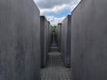 Narrow corridor made of high concrete blocks of the Memorial to the Murdered Jews of Europe in Berlin Royalty Free Stock Photo