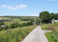 Narrow country lane with the village of wadworth and hillside fields near hebden bridge in calderdale west yorkshire