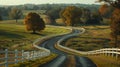 A narrow country road winds through fields and pastures, with majestic trees and white fences along the sides in Midwest Royalty Free Stock Photo