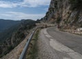 Narrow dangerous asphalt road at Genna Croce pass. at Supramonte Mountains with white limestone rocks, green hills