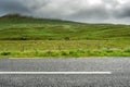Narrow empty asphalt road by a green fields and hills, Low cloudy sky over peaks. Nobody, Connemara, Ireland. Concept travel, road Royalty Free Stock Photo