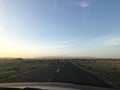 Narrow empty asphalt road under a blue cloudy sky during the daytime Royalty Free Stock Photo