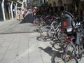 Narrow European street, women and girls are walking. Bicycle parking