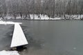 A narrow footbridge to the newly frozen pond. Royalty Free Stock Photo