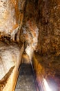 Narrow footpath in limestone cave. Royalty Free Stock Photo
