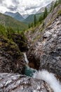 Narrow gorge with a small river and a waterfall. Royalty Free Stock Photo