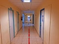 Narrow hospital corridor with low light and closed rooms Royalty Free Stock Photo