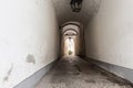 Narrow inner paved stone urban street road passage in old european city. Vintage dark alley with lamp lantern and grey