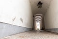 Narrow inner paved stone urban street road passage in old european city. Vintage dark alley with lamp lantern and grey