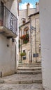 narrow Italian street with steps and balconies with flowers