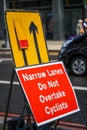 Narrow Lanes Do Not Overtake Cyclists sign below a lane closure traffic sign Royalty Free Stock Photo