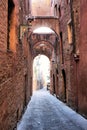 Narrow medieval arched street in Siena, Italy