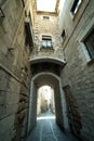 Narrow medieval street with arch in Girona city, Spain