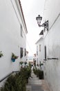 Narrow Mijas street with beautiful flowers in a pots on the facade. Charming white village in Andalusia. Costa del Sol. Royalty Free Stock Photo
