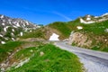 Narrow mountains road from Col de Lautaret to Col du Calibier, Mountains and alpine meadows views of Massif des Ecrins, Hautes Royalty Free Stock Photo