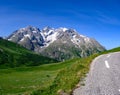 Narrow mountains road from Col de Lautaret to Col du Calibier, Mountains and alpine meadows views of Massif des Ecrins, Hautes Royalty Free Stock Photo