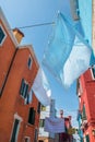Narrow old Burano island streets with colorful houses and hinged drying linen, Venice, Italy. Very attractive famous travel Royalty Free Stock Photo