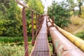 A narrow old rusty river crossing, along with a water and gas pipe. Communications in the village