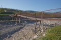 A narrow old rusty river crossing . Dirty, stony river . a suspension bridge still made of an iron stand was used to cross the Royalty Free Stock Photo