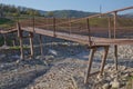 A narrow old rusty river crossing . Dirty, stony river . a suspension bridge still made of an iron stand was used to cross the Royalty Free Stock Photo